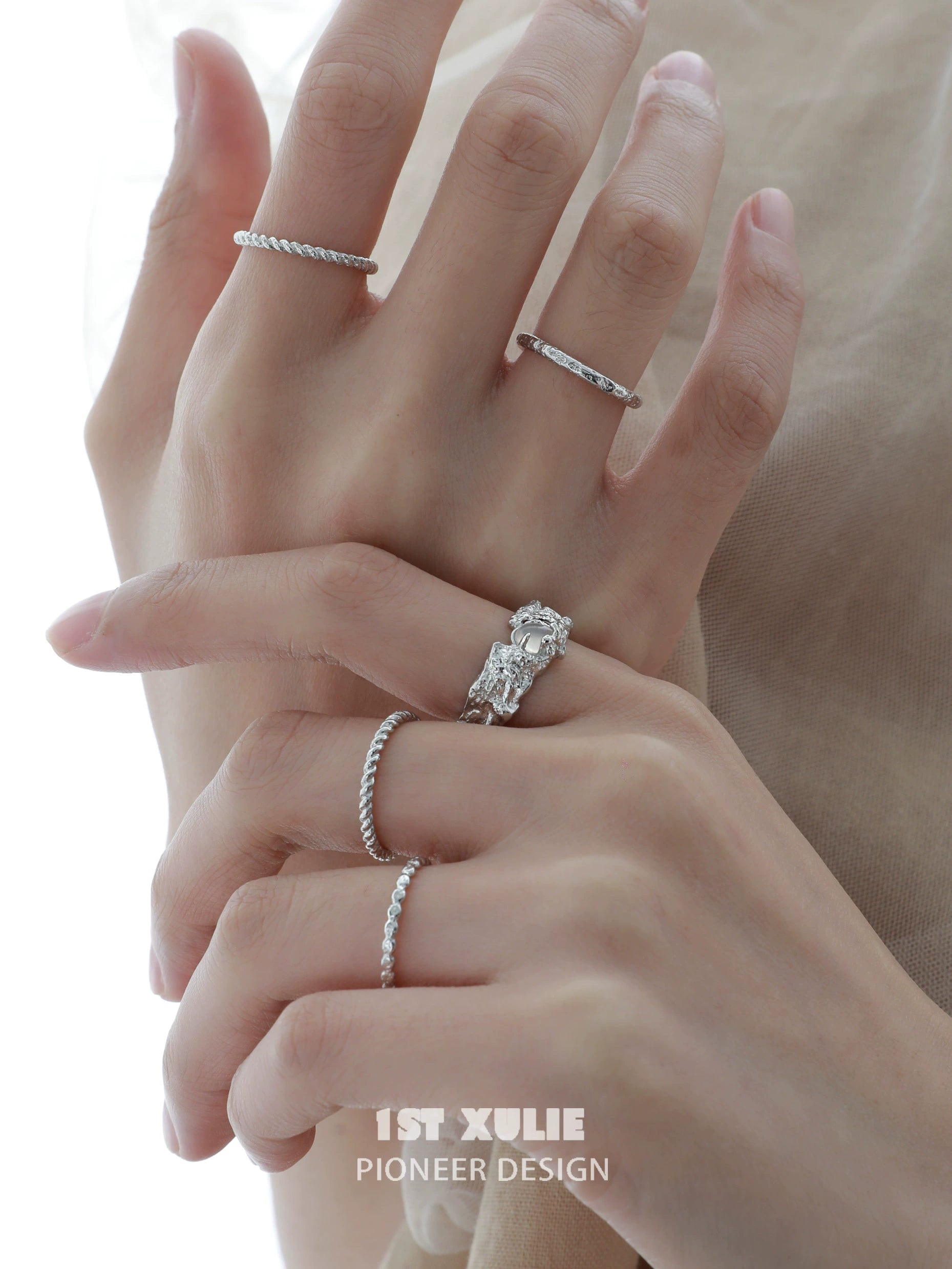 Elegant white agate ring showcased alongside other delicate silver rings on a hand
