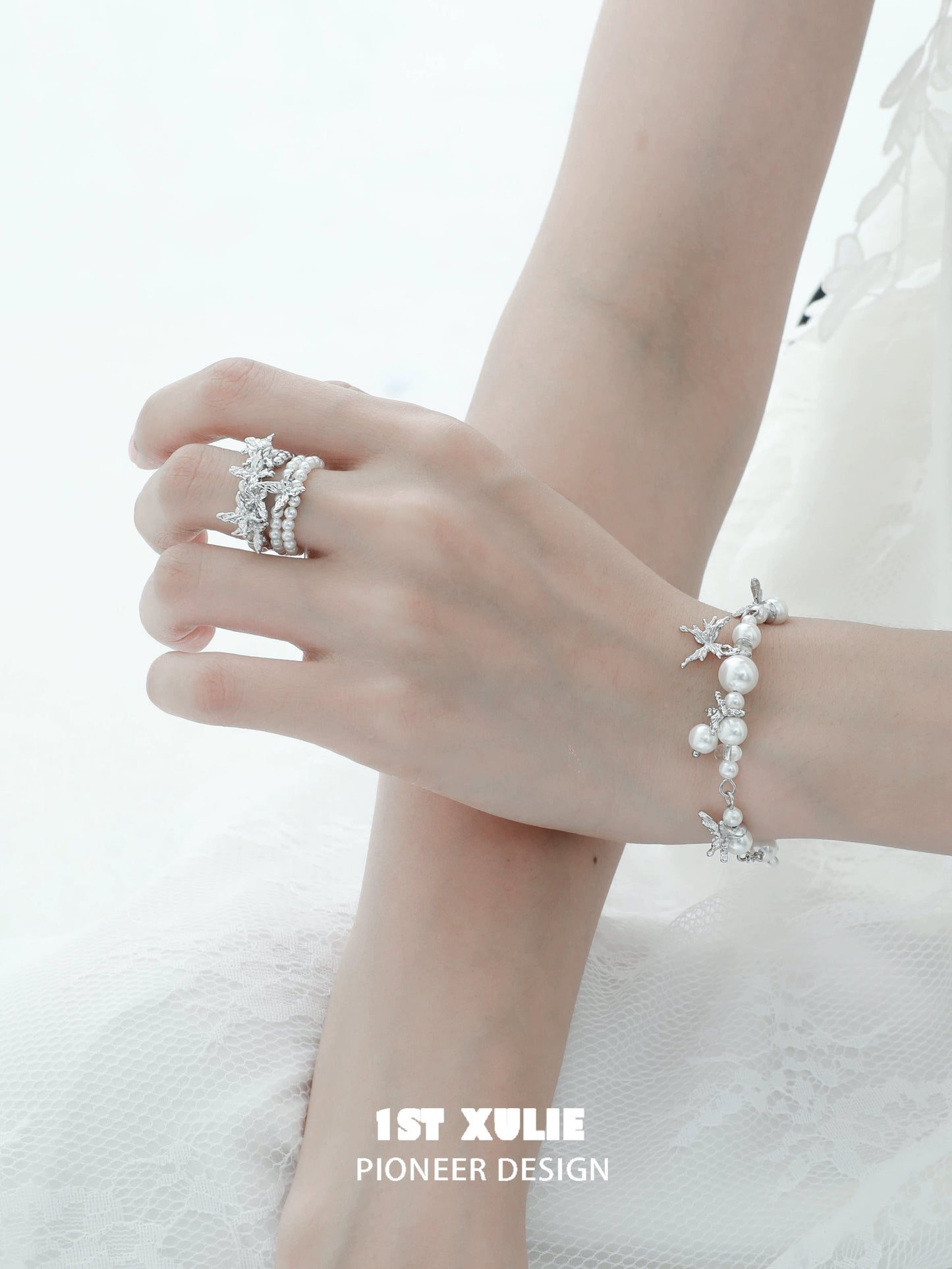 Elegant white butterfly pearl bracelet showcased on a delicate hand with matching silver jewelry