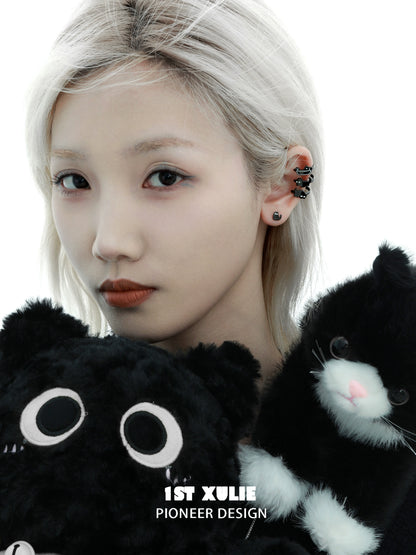 Y2K black cat earrings featured on model holding plush black cat toys with a stylish look