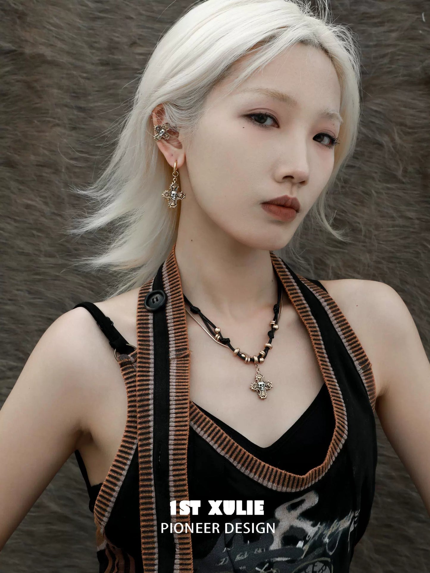 Y2K cross earrings in gold worn by model with platinum hair and stylish outfit