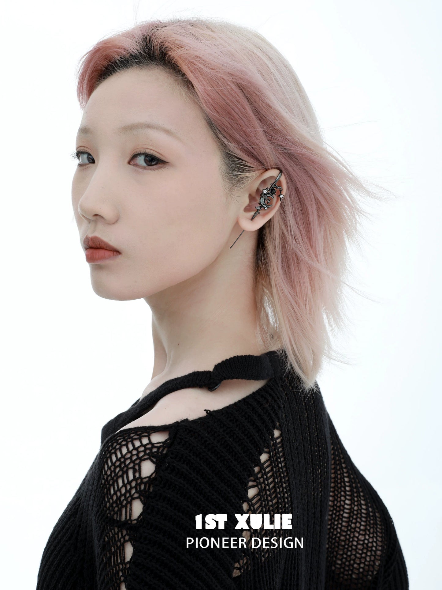 Y2K dark moon ear piercing showcased on a model with trendy hairstyle and black knit top