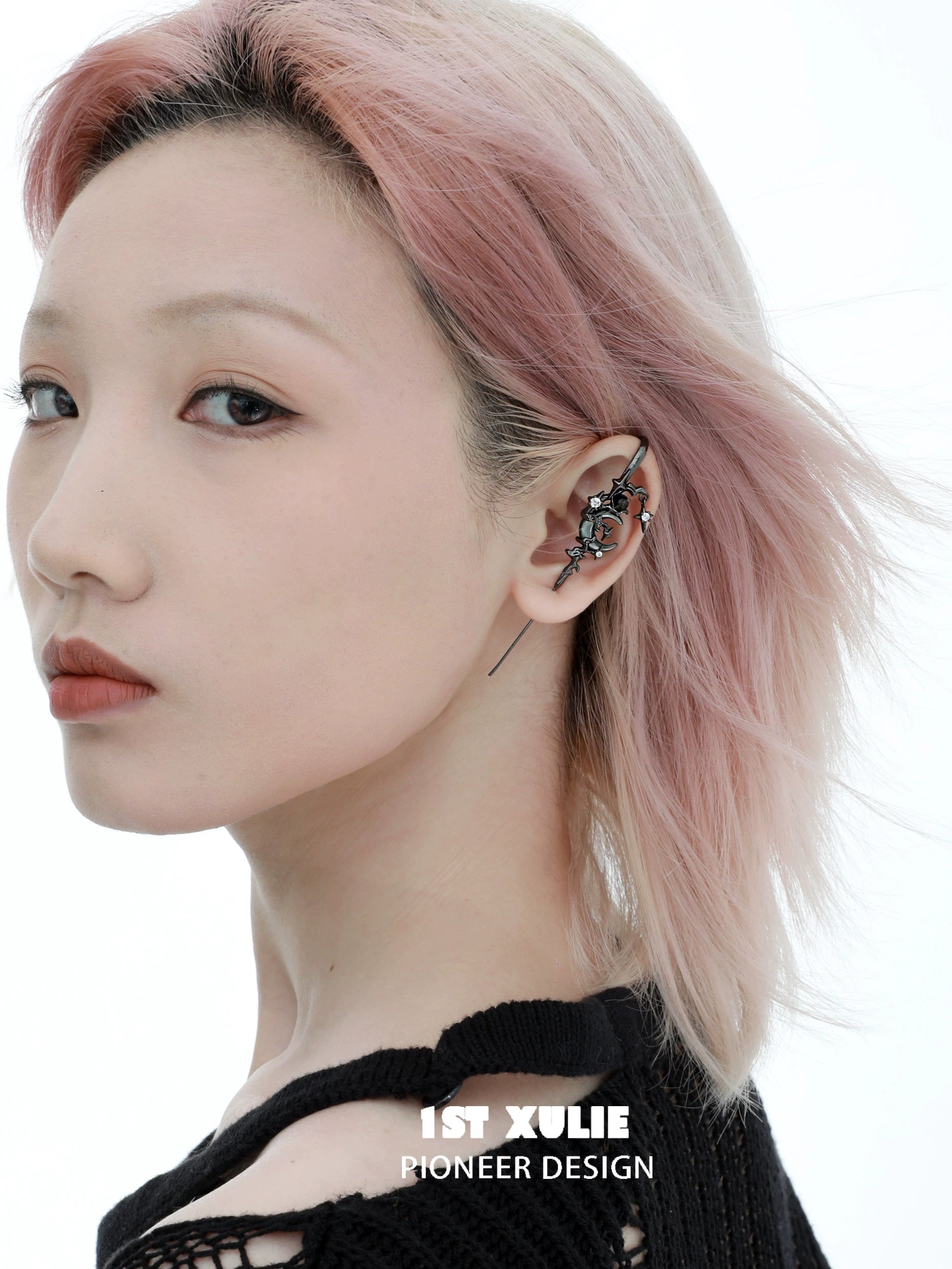 Y2K dark moon ear piercing design displayed on model with stylish pink hair