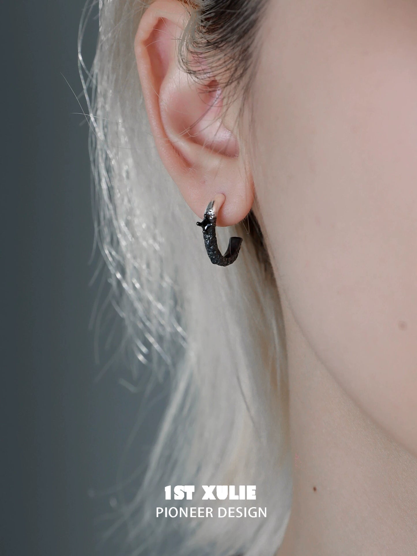 Y2K fire earrings in black, showcasing a unique design worn on a model's ear