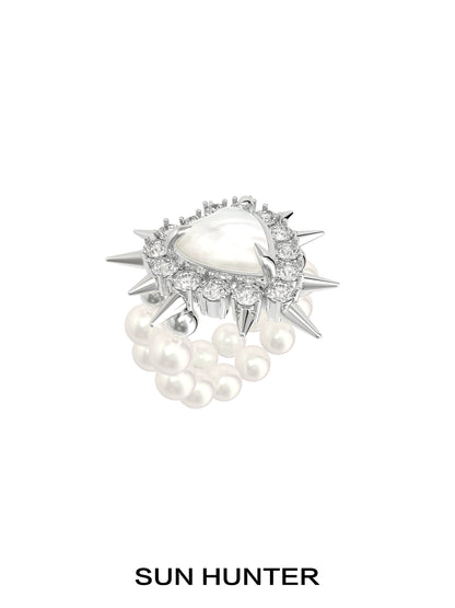 Y2K pearl rivet ring by SUN HUNTER featuring a spike design with pearl accents and a central gem