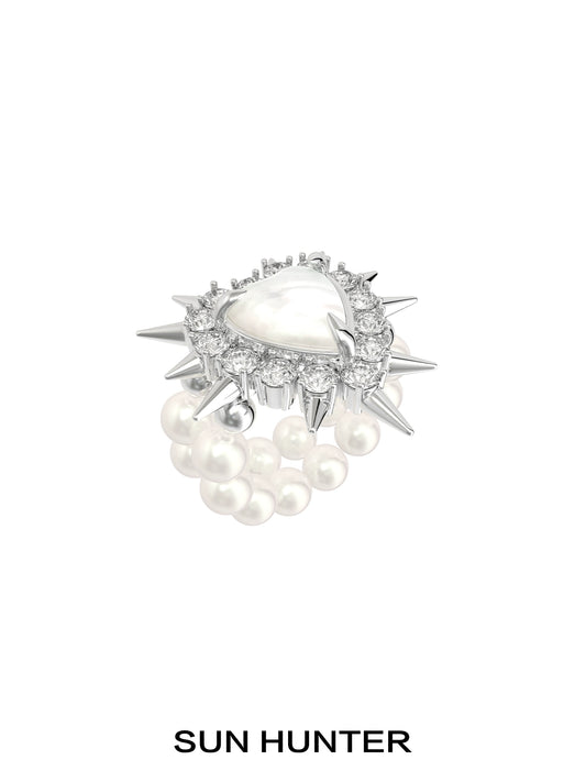 Y2K pearl rivet ring by SUN HUNTER featuring a spike design with pearl accents and a central gem