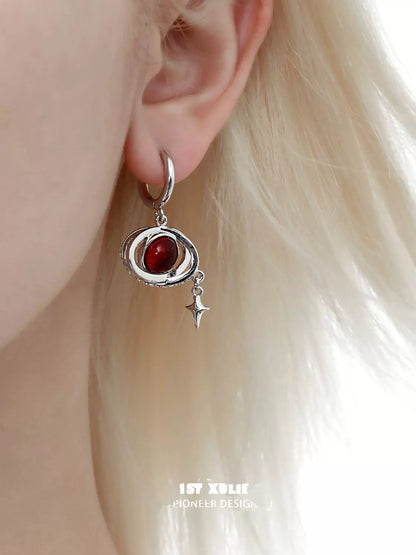 Y2K red planet earrings with a silver spiral design and a dangling star charm