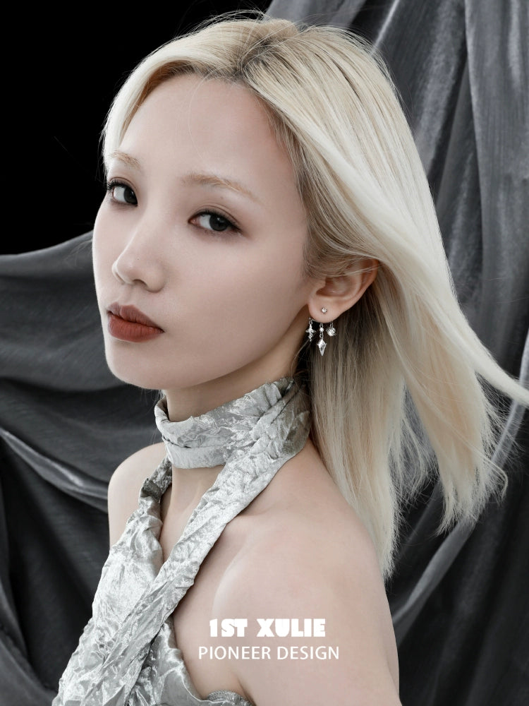 Model wearing Y2K snake earrings with a modern silver outfit against a dark background