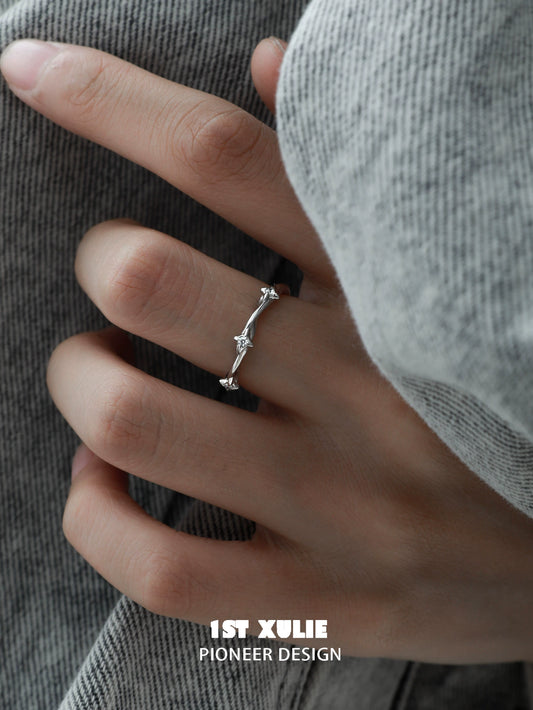 Y2K twisted spiral silver ring worn on a hand with a cozy sweater background